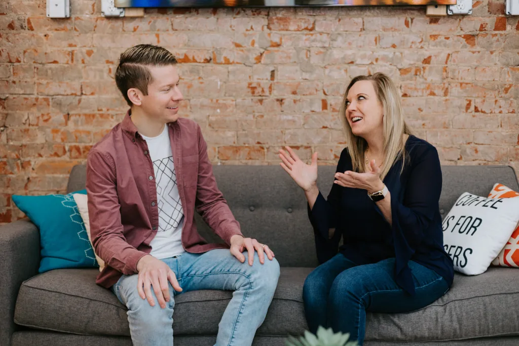 The Importance of a Mentoring Culture (and How to Build One) 6 Man and woman on a couch discussing career mentoring advice.